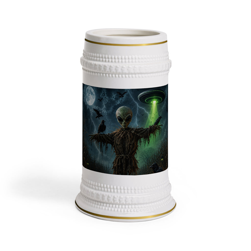 Front view of a white ceramic stein with gold trim, showing an alien scarecrow, ravens, a full moon and a green UFO beam.
